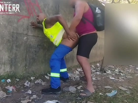 Two African American men having sex in public, one of them is dressed in work clothes.